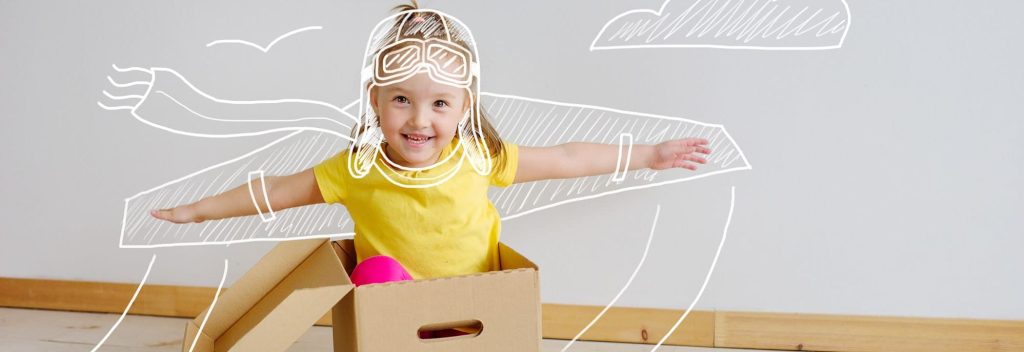 Petite fille jouant à l'avions avec un carton de déménagement - la bellenergie