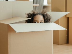 Petite fille dans un carton de Déménagement