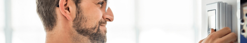 Personne regardant un thermostat