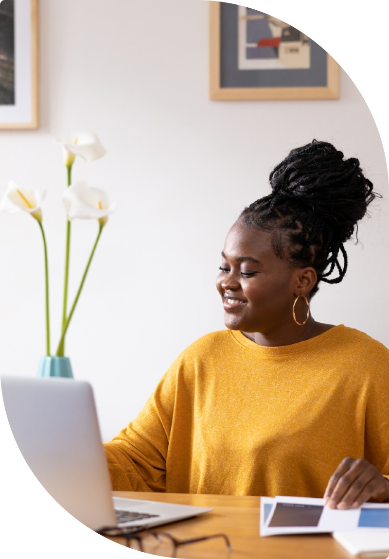 Femme heureuse sur ordinateur chez elle