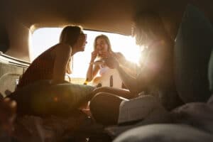 Amies jouant de la musique sur un soleil couchant dans un van